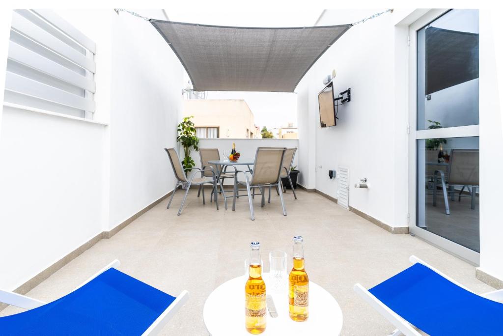 阿依纳帕Spiros Luxury Apartments的庭院配有2张桌子和椅子,并提供饮品