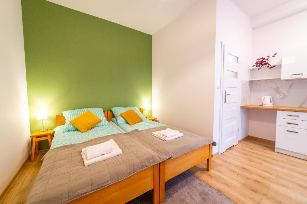 米科瓦伊基Pokoje u Matiego的一间卧室设有一张大床和绿色的墙壁
