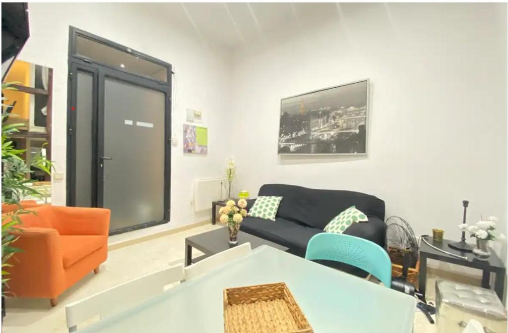 马德里ILE BUENA VISTA EXTERIO的客厅配有黑色沙发和橙色椅子