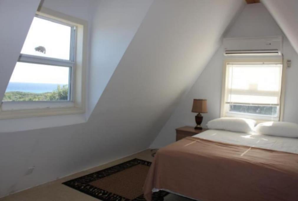 Gregory TownSea view Pointe的一间卧室设有一张床和两个窗户。