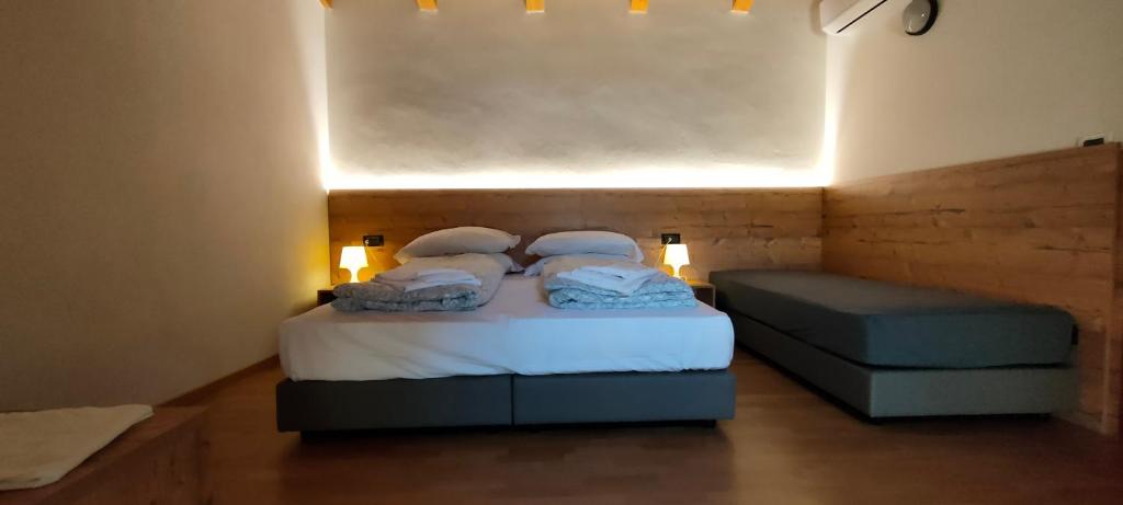 加尔达湖滨卡萨弗朗西斯酒店的一间小房间,配有两张床和一张沙发