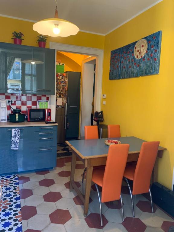 都灵Maria Vittoria House的厨房配有桌子和橙色椅子