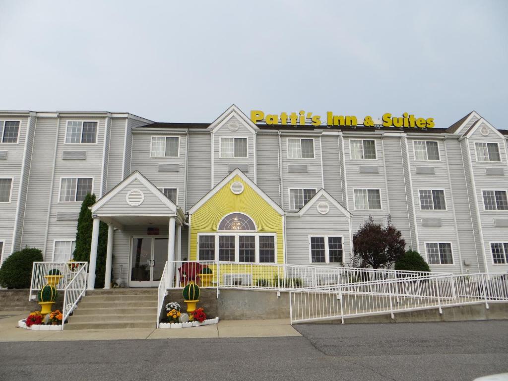 Grand RiversPatti's Inn and Suites的一座白色的大建筑,上面有黄色的标志