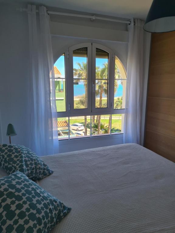 马拉加Cozy Beach Apartment的一间卧室设有一张床和一个大窗户
