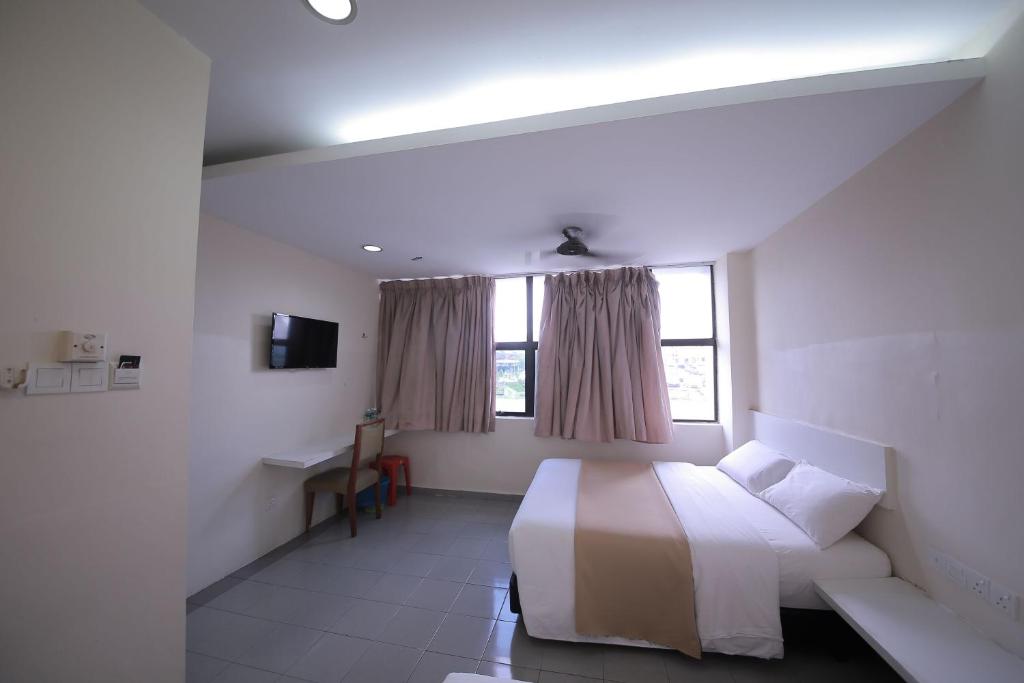 士姑来OYO 1010 Skudai Hotel的白色的卧室设有床和窗户