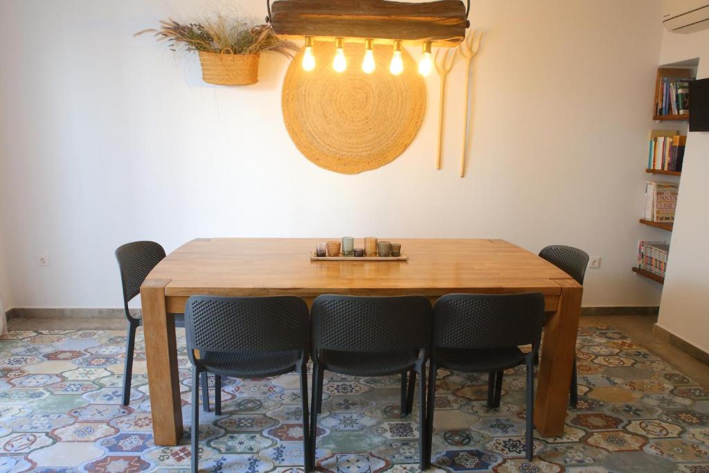 特乌拉达Casa Sant Vicent 63的一间带木桌和椅子的用餐室
