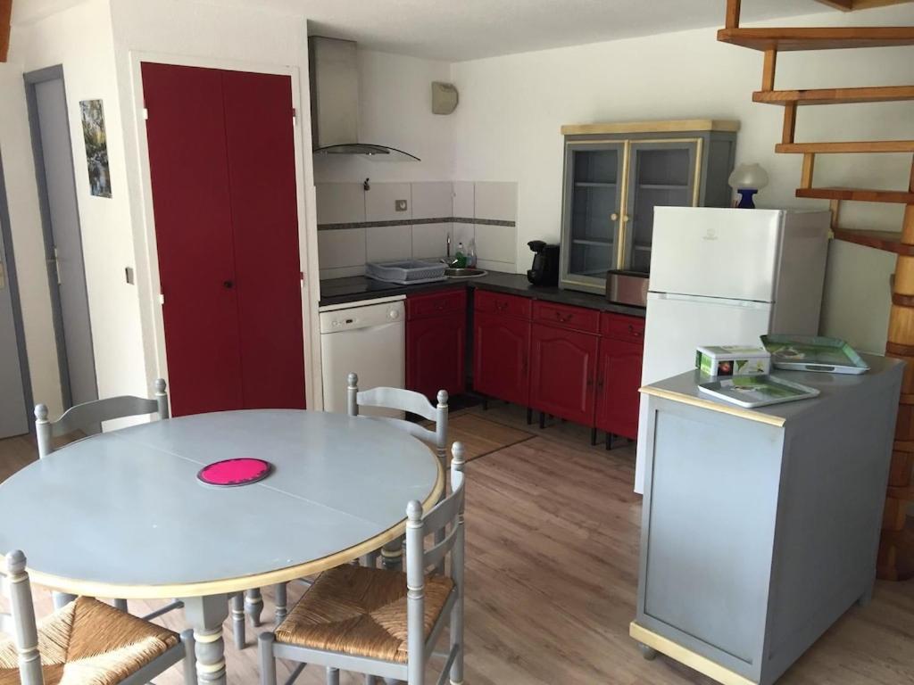 拉兰Appartement sur le bord du lac de fabreges的厨房配有桌子和白色冰箱。