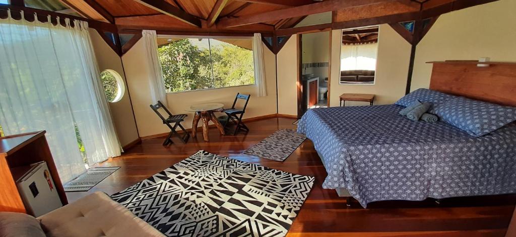 韦尔卡鲍Casa Flor da Vida - Vale do Capao的卧室配有一张床和一张桌子及椅子