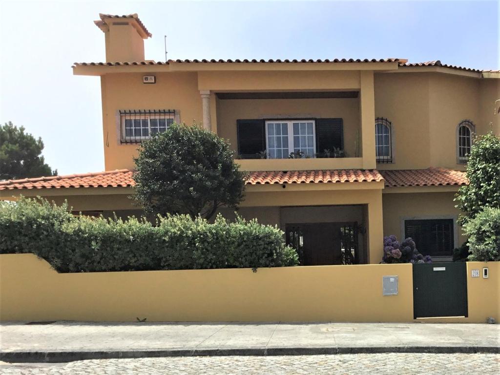 Vila ChãFerienhaus Casa do mar mit seitlichem Meerblick的前面有黄色围栏的房子