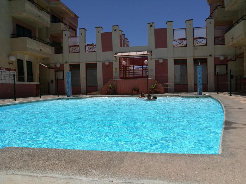 阿里纳加Arinaga Beach & Pool Apartment的大楼前的大型游泳池