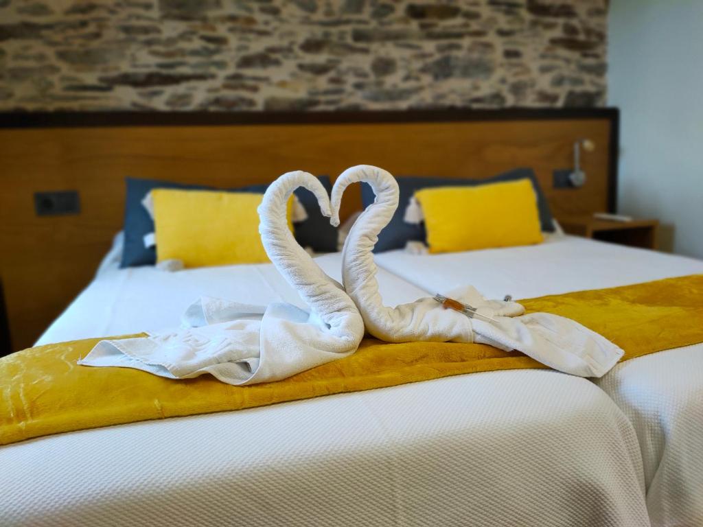 萨尔塞达Pension Albergue Alborada的床上的两条毛巾天鹅