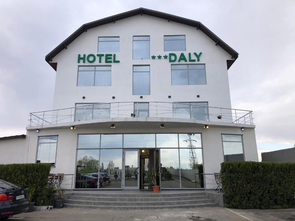 普洛耶什蒂Hotel Daly的带有酒店日读物标志的酒店大楼