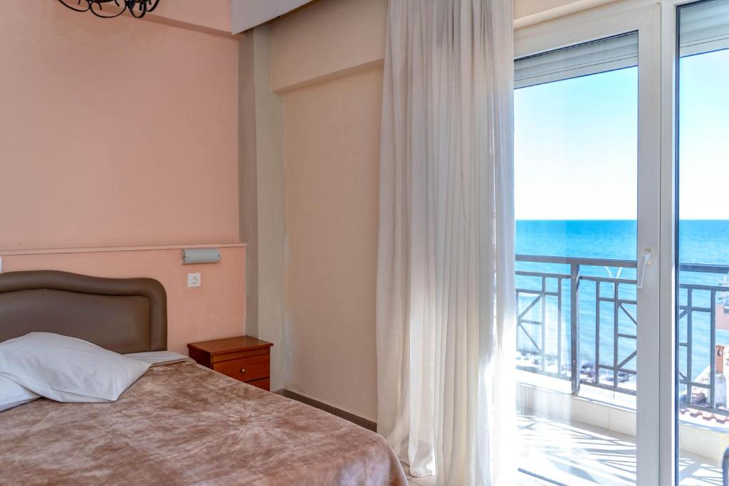 亚历山德鲁波利斯阿尔肯酒店的一间卧室配有一张床,享有海景
