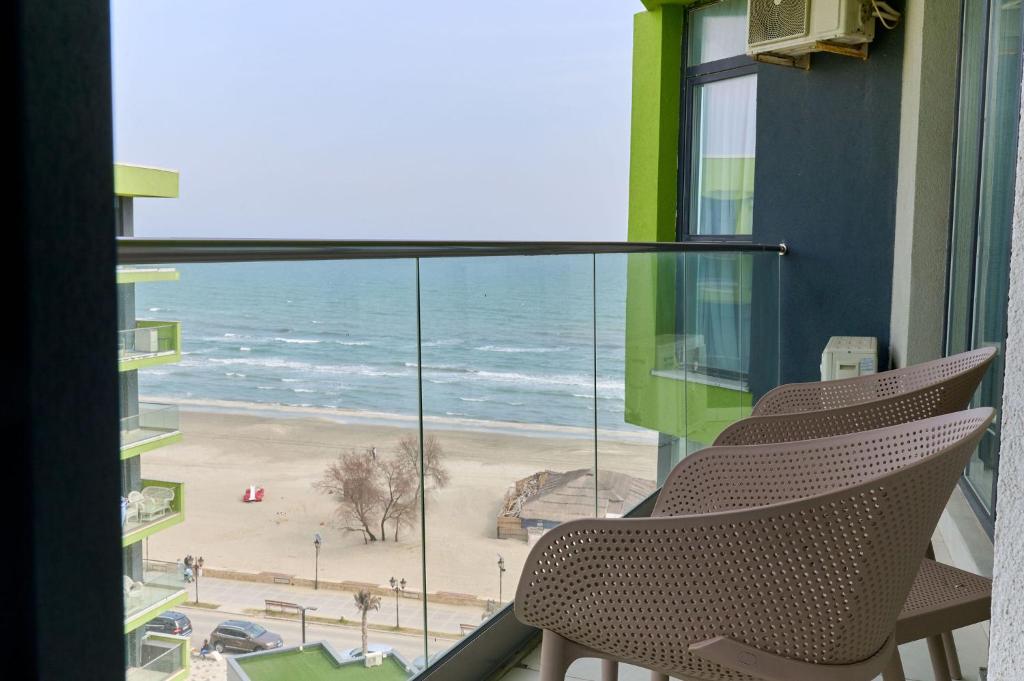 马马亚Olive apartment in Spa n Pool Resort-parking的阳台配有两把椅子,享有海滩美景。