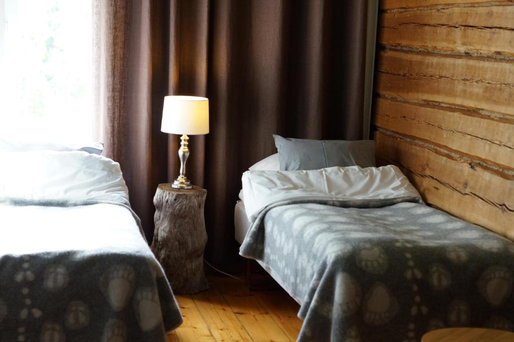 KannonkoskiBear Manor B&B的一间卧室设有两张床和一盏靠窗的灯。