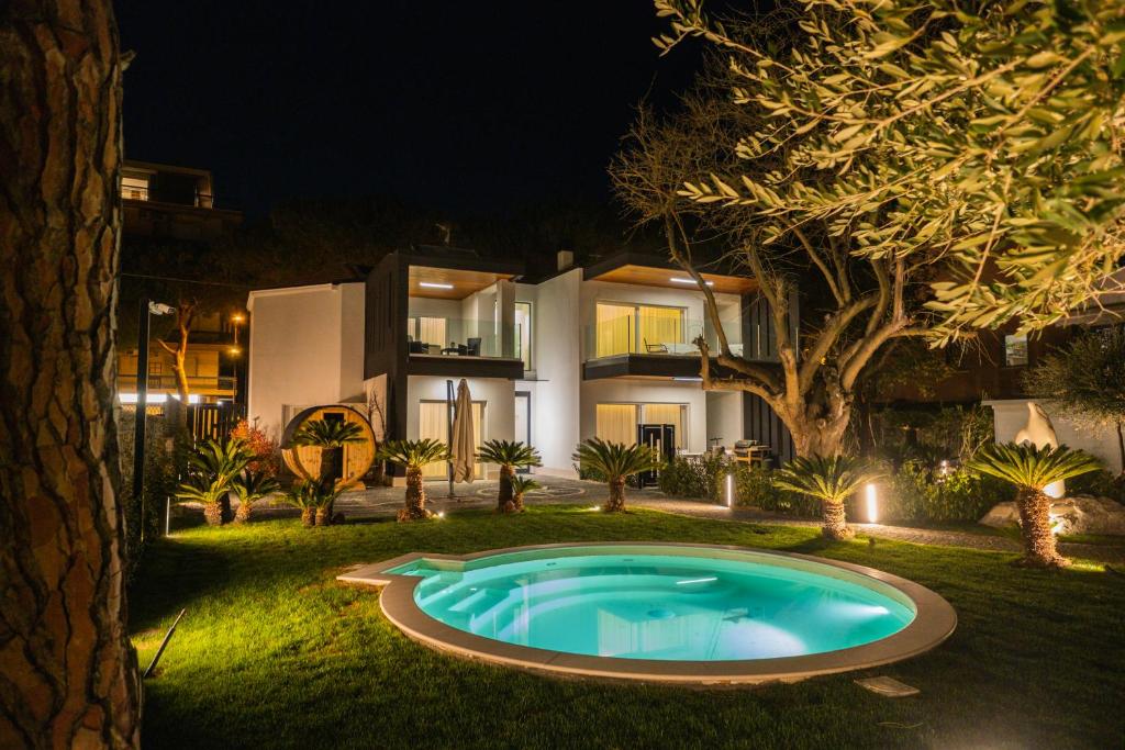 佩斯卡拉Luxury B&B La Riserva Dannunziana的夜晚在房子前面的游泳池