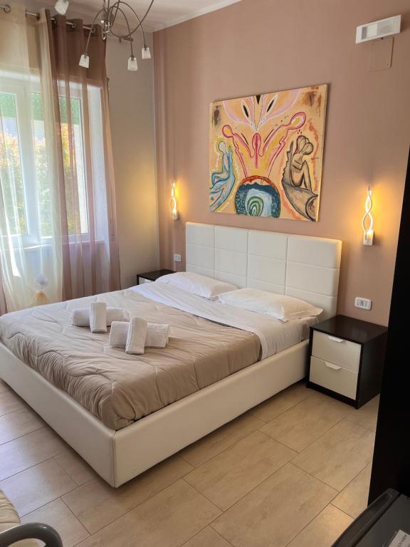 普拉亚·阿马勒B&B Villa degli Angeli的卧室内的一张大床,墙上有绘画作品