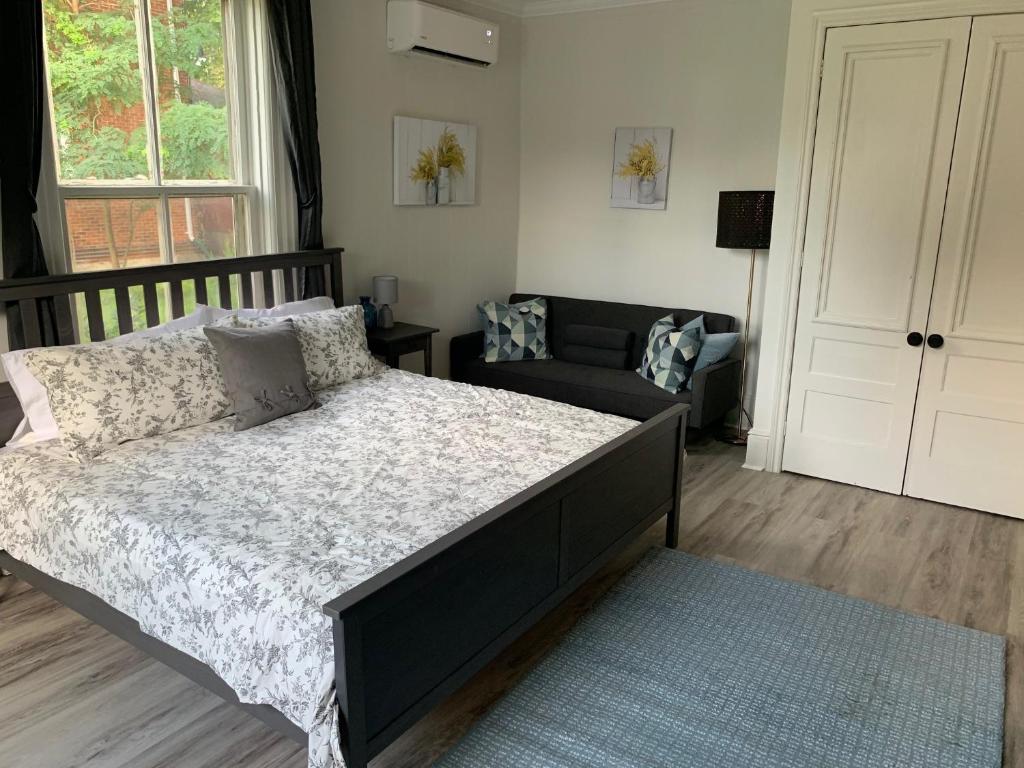 惠灵顿County Cove - Picton Suite的一间卧室配有一张大床和一张沙发