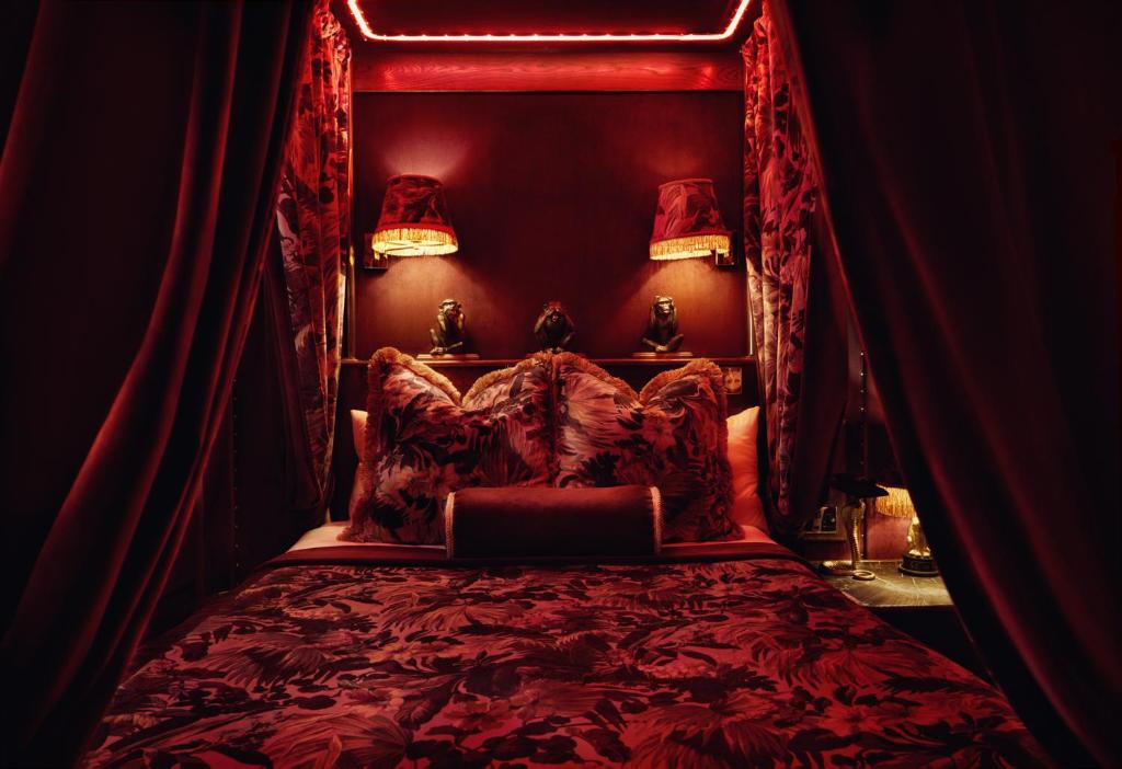 爱丁堡House of Gods Royal Mile的一间卧室配有一张红色天蓬床