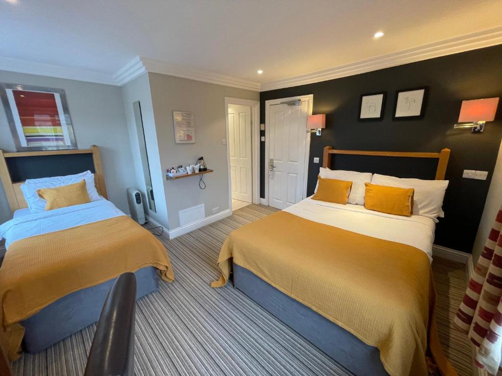 泰晤士河畔里士满Shandon Hotel的一间卧室设有两张黄色和蓝色的床