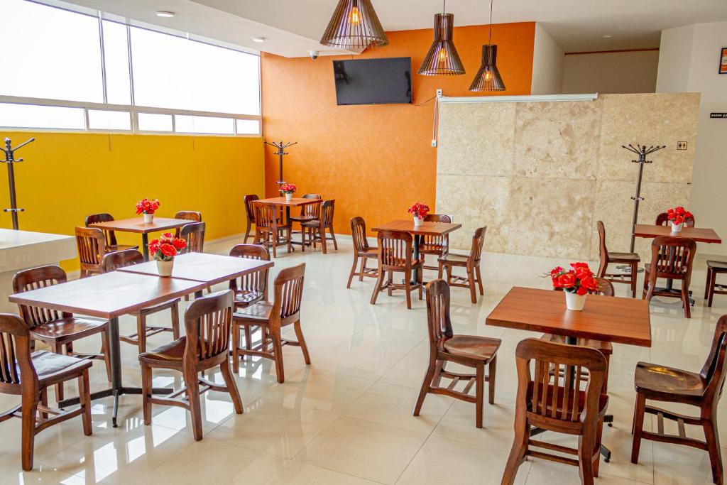 贾拉普Hotel Klimt的餐厅设有桌椅和黄色的墙壁