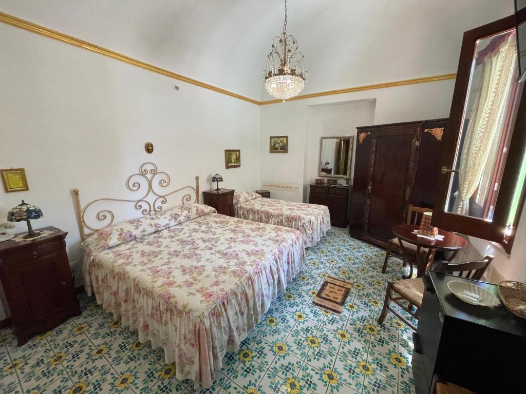 法维尼亚纳Guest House Al Gattopardo的一间卧室配有两张床和吊灯。