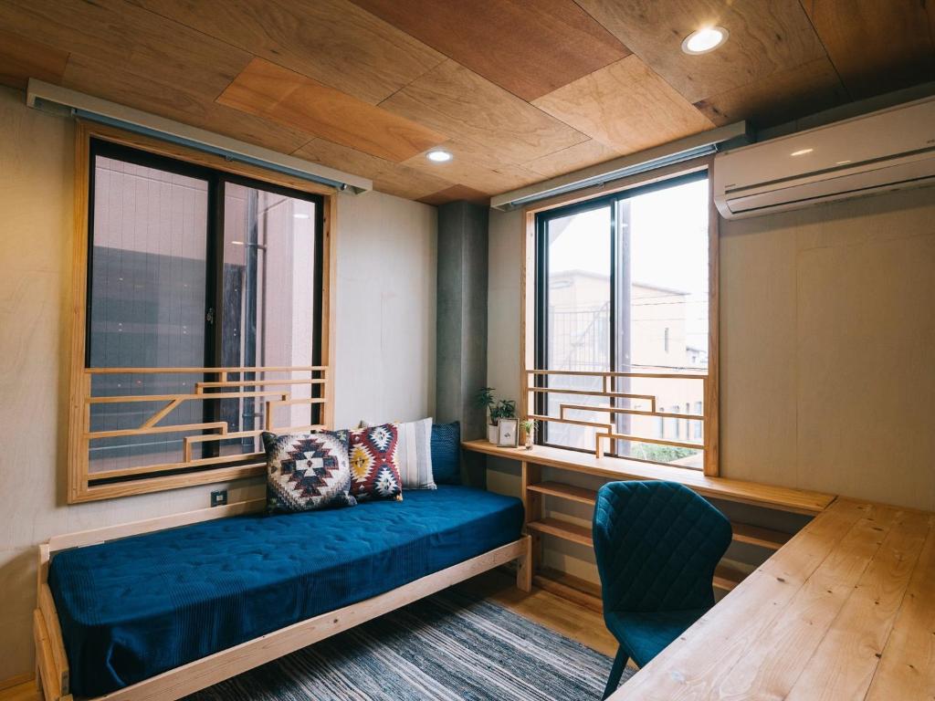 荒尾Noasobi Lodge 205- Vacation STAY 44527v的一间设有蓝色沙发和窗户的客房