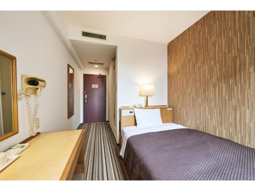 浦安Urayasu Sun Hotel - Vacation STAY 32992v的配有一张床和一张书桌的酒店客房