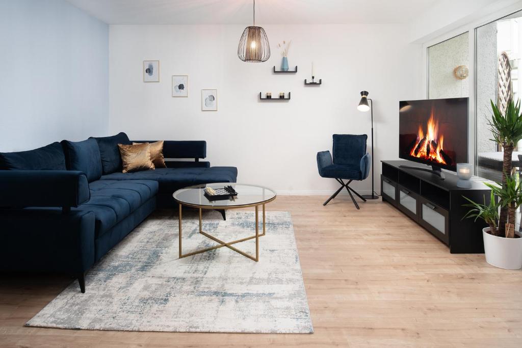 萨尔斯塔特Aparte - Washer & Dryer - Kitchen & Parking - Smart-TV的客厅设有蓝色的沙发和壁炉