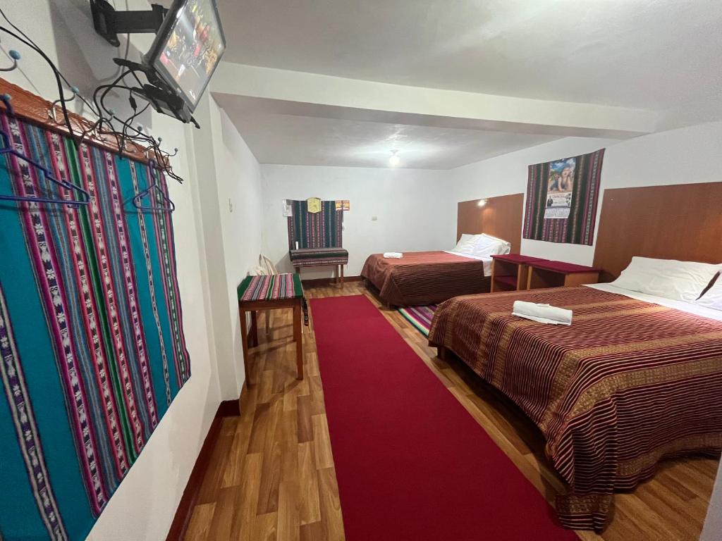 普诺Hotel Wiñay Pacha Inn的酒店客房,设有两张床,铺有红地毯。