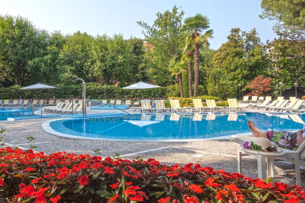 阿巴诺泰尔梅布里斯托尔布加酒店的度假村内带椅子和鲜花的游泳池