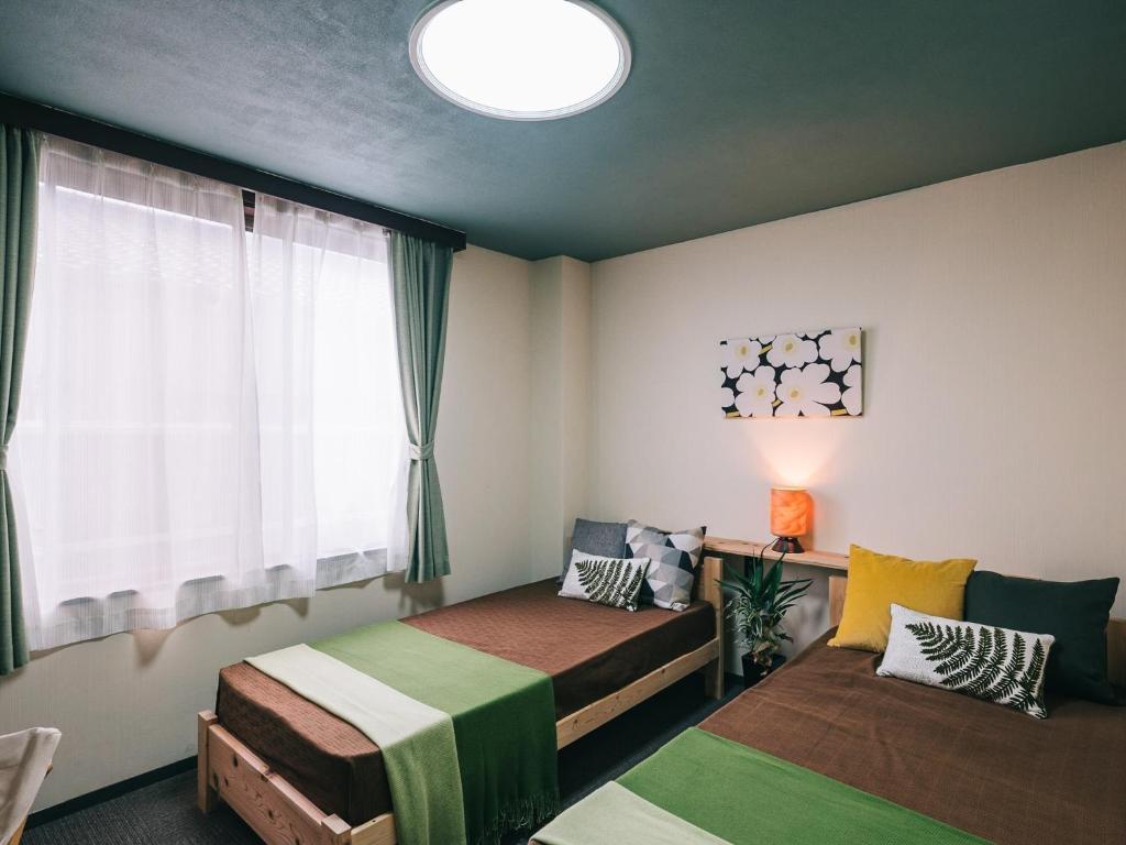 荒尾Noasobi Lodge 203- Vacation STAY 23343v的一间卧室设有两张床和窗户。