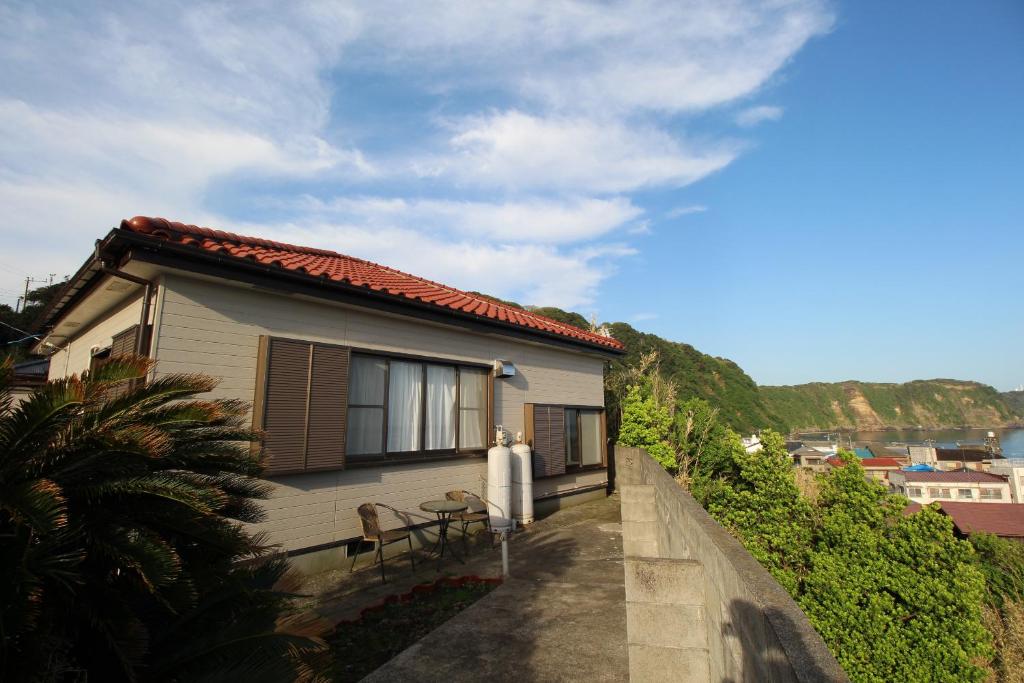 大岛香や野 kayano 海と富士山を一望できる1棟貸し宿 岡田港まで徒歩5分的旁边设有桌椅的房子