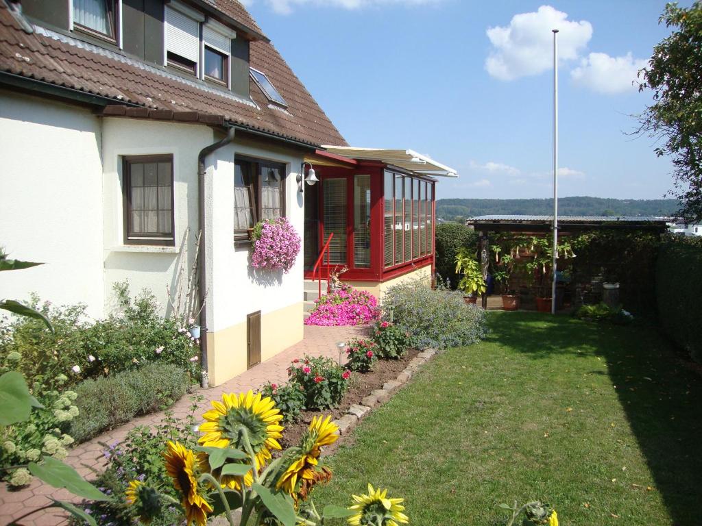 DombühlHaus Reif的庭院里带花卉的花园的房子