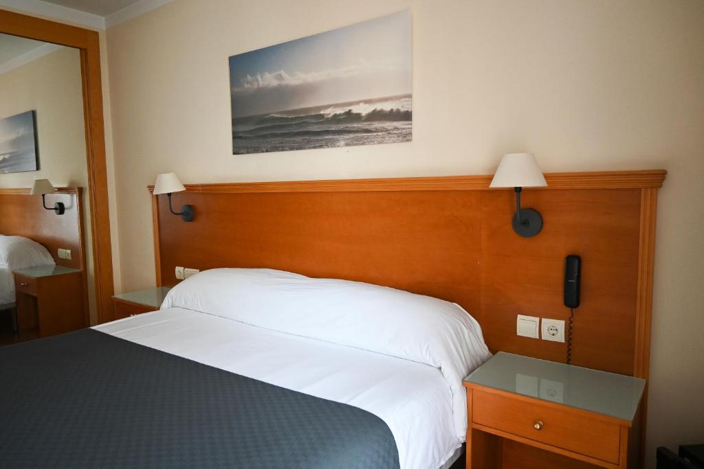 马贝拉卡塔莉娜夫人酒店的一间卧室配有一张带木制床头板的床