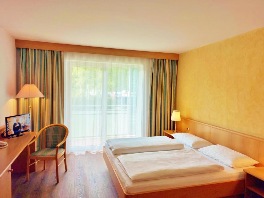维皮泰诺Hotel Brenner - Stop & Go的酒店客房设有两张床、一张书桌和一个窗户。