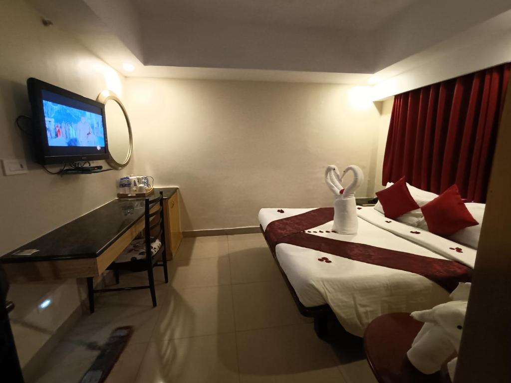 钦奈萨维拉酒店的酒店客房设有两张床和电视。