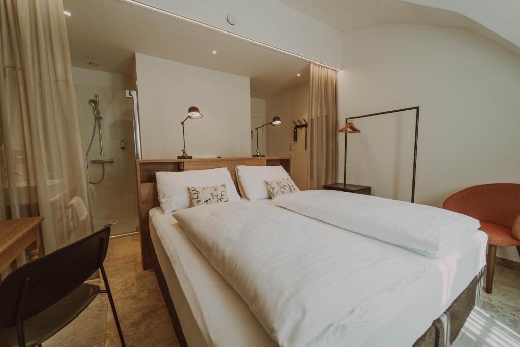 StadtschlainingBurghotel Schlaining的卧室配有一张白色大床和一张书桌