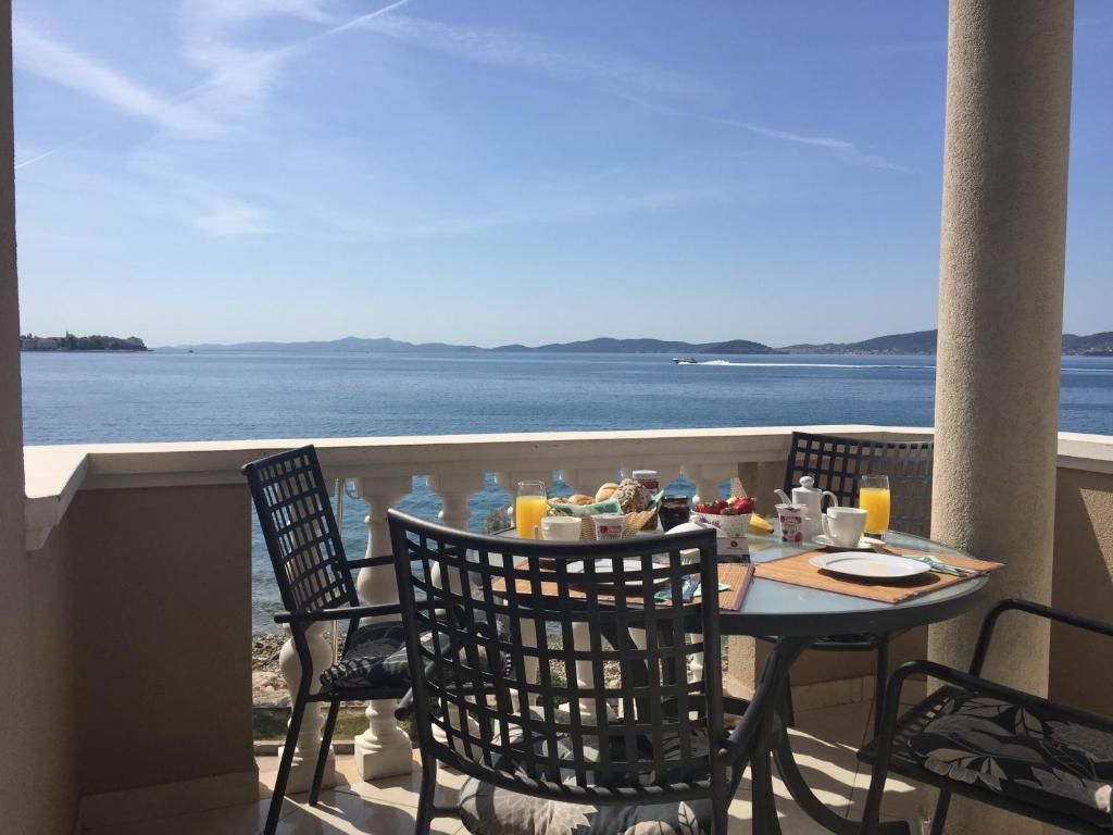 扎达尔蓬塔别墅酒店的海景阳台上的桌椅