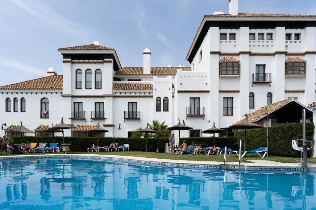 马塔拉斯卡尼亚斯Moon Dreams El Cortijo的一座白色大建筑前的游泳池