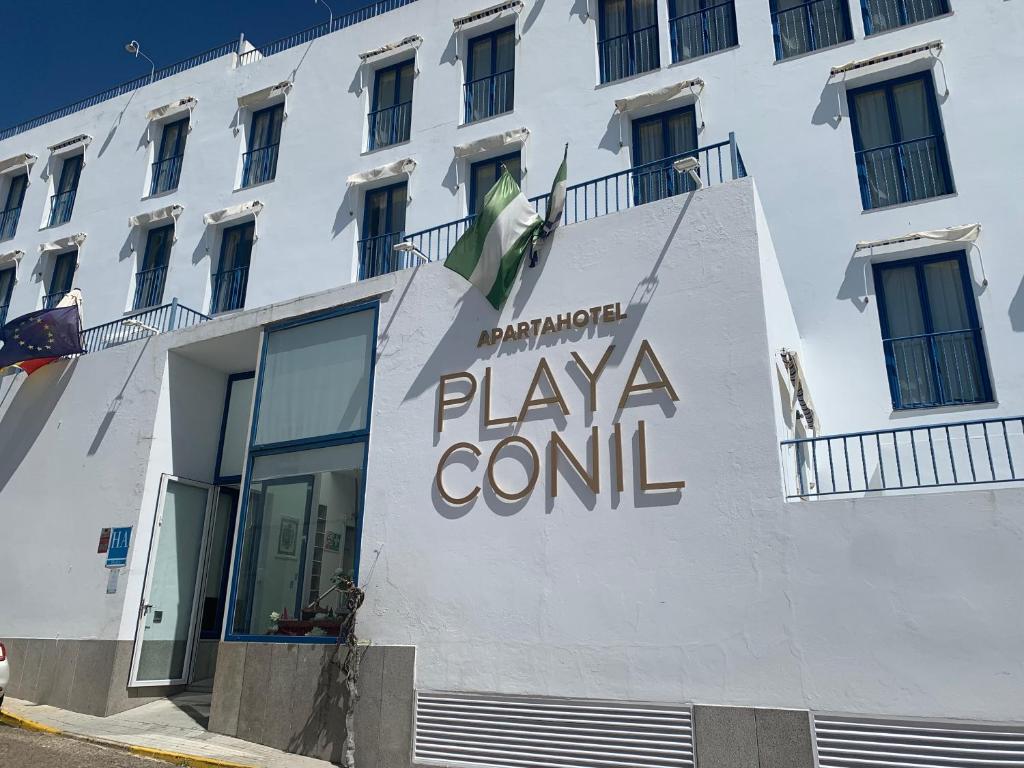 科尼尔-德拉弗龙特拉Apartahotel Playa Conil的上面有控制游戏标志的白色建筑