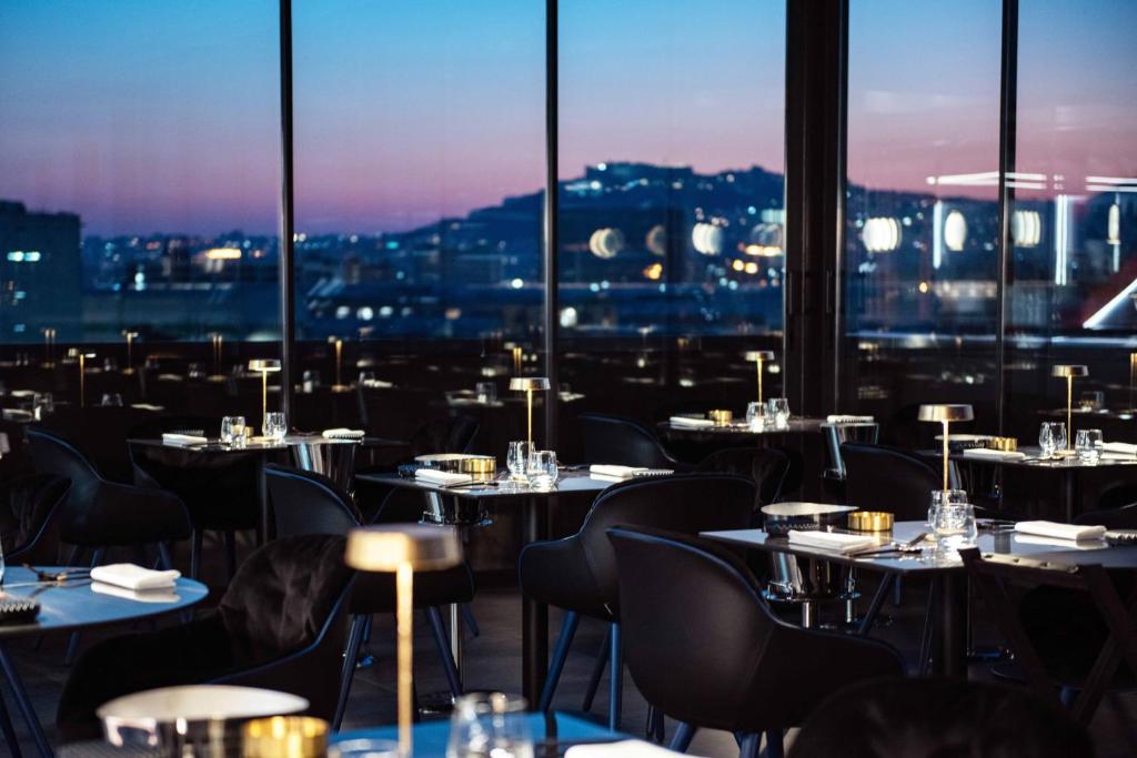 那不勒斯Gold Tower Lifestyle Hotel的一间带桌椅的市景餐厅