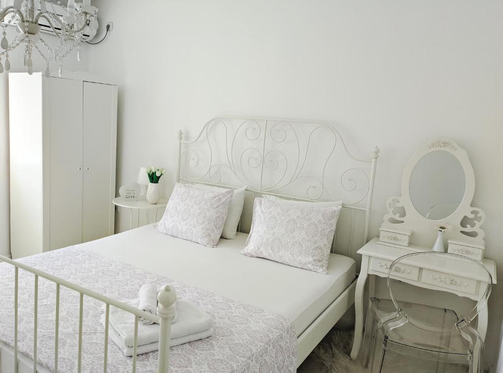 帕里斯特M&M apartment & rooms的白色的卧室配有白色的床和镜子