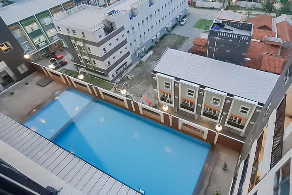 万隆RedLiving Apartemen Mekarwangi Square - Agus 2 Tower A的享有带游泳池的大楼的顶部景致