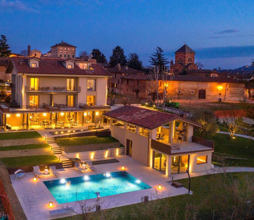 VerdunoAgriturismo Speziale Wine Resort的一座大型豪宅,晚上设有游泳池