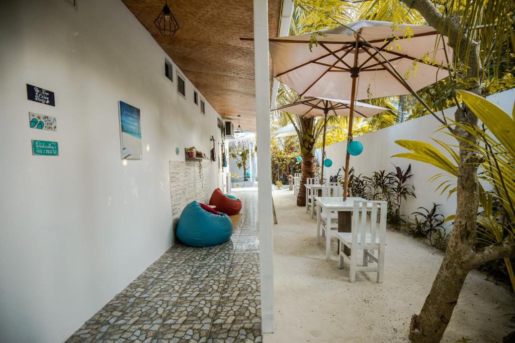 马提威力Mystic Maldives Mathiveri Retreat的一个带桌子和遮阳伞的庭院