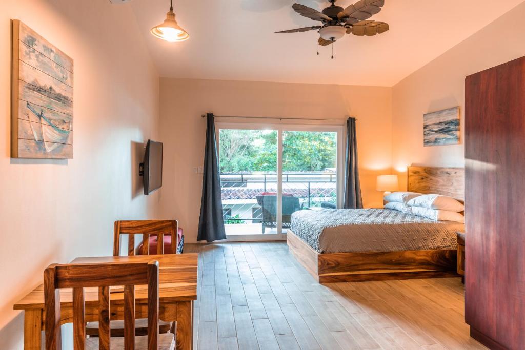 格兰德海滩Palm Beach Inn的一间卧室配有一张床、一张桌子和一个窗户。