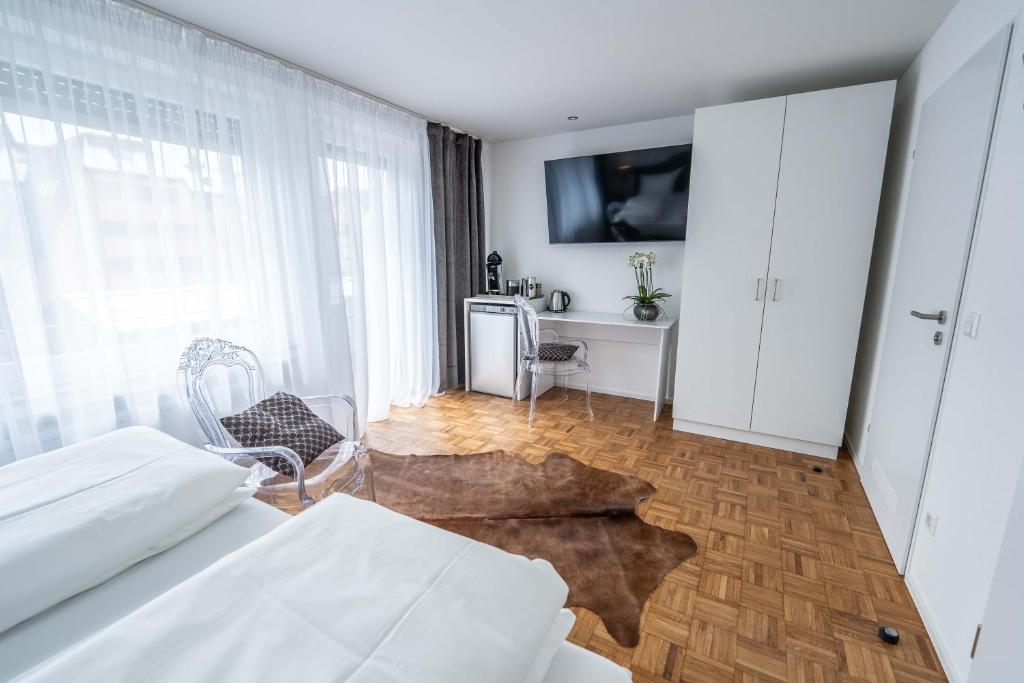 腓特烈港City Apartments FN L 6 KLIMATISIERT mit Balkon - Deluxe Doppelzimmer的一间卧室配有一张床,墙上配有电视