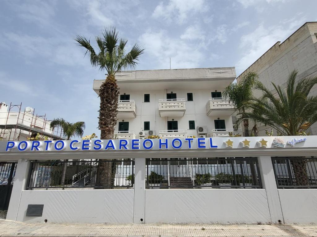 切萨雷奥港Porto Cesareo Hotel的一座建筑前有棕榈树的酒店