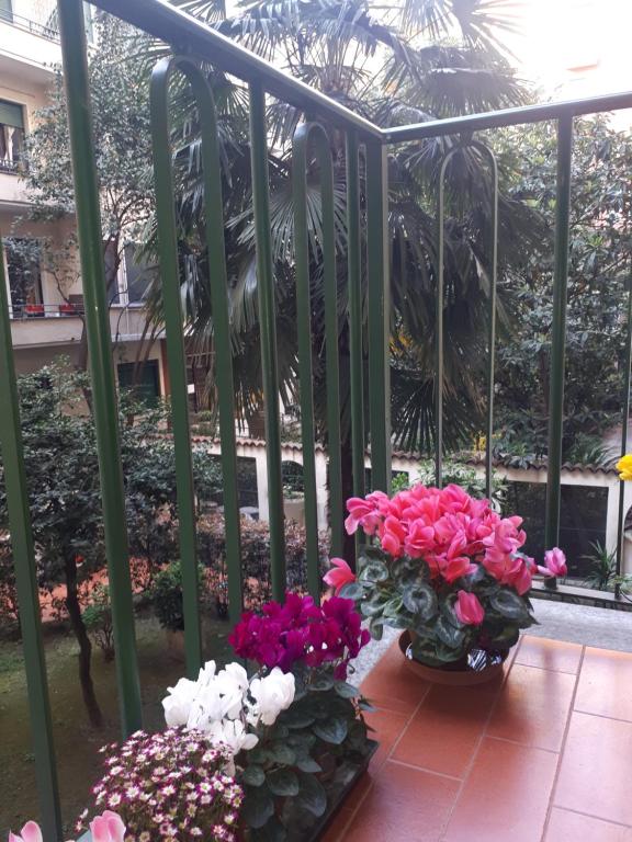 米兰Appartamento Diego的两个花瓶,花朵盛在阳台上